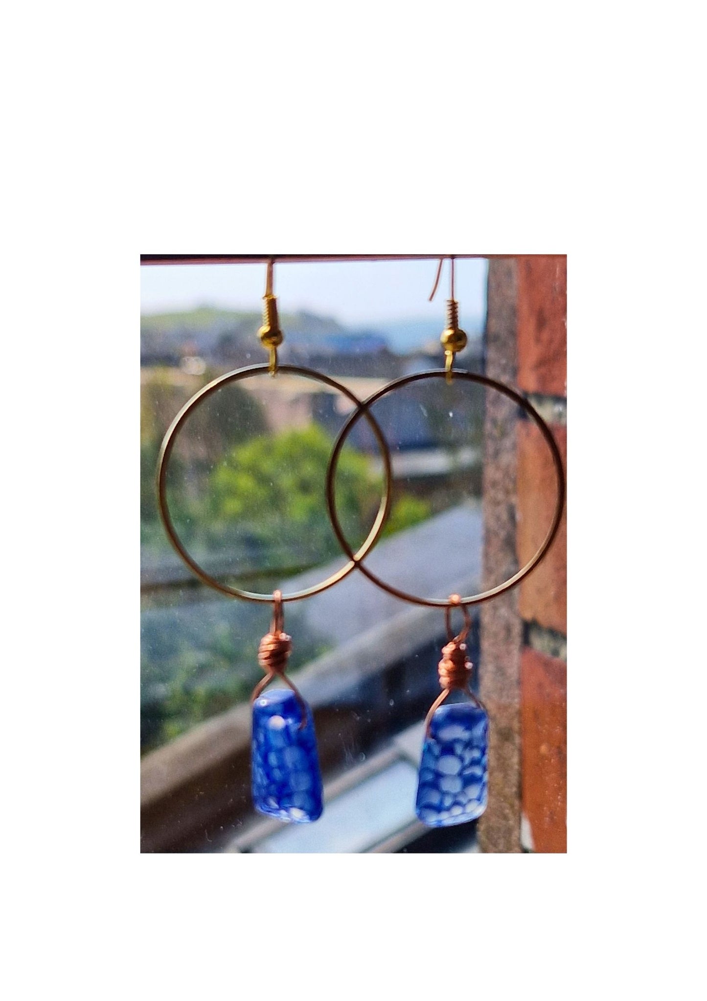 Gold hoop earrings with blue glass beads.